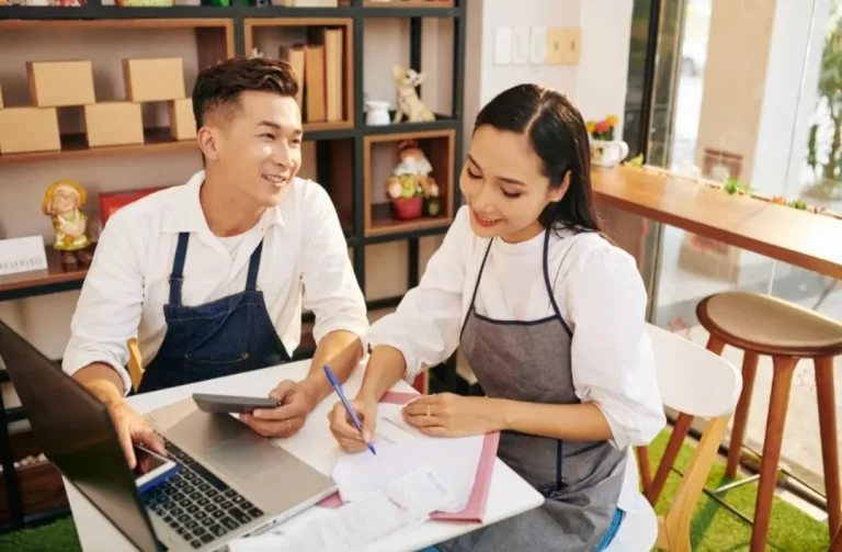 Small business owners discussing and analyzing financial documents together