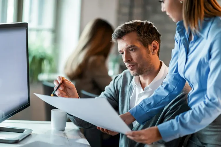 Focused business professionals reviewing documents together in a modern office setting